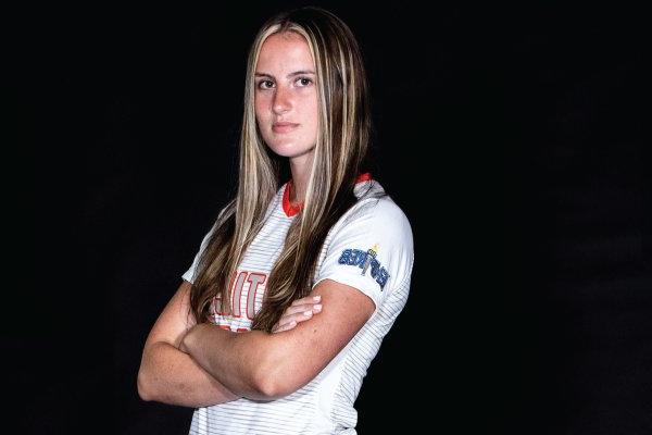 Kela Mochak, Class of 2024, stands with arms folded in soccer uniform.